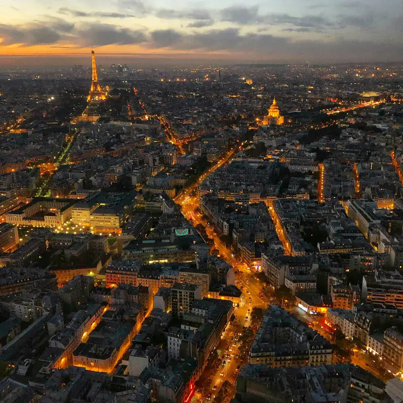 Paris centre at dusk, the streets glowing orange and the Eiffel Tower in view