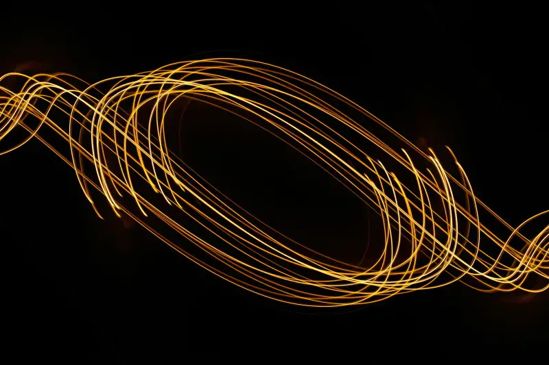 Streaks of light swirl around in unison against a dark background