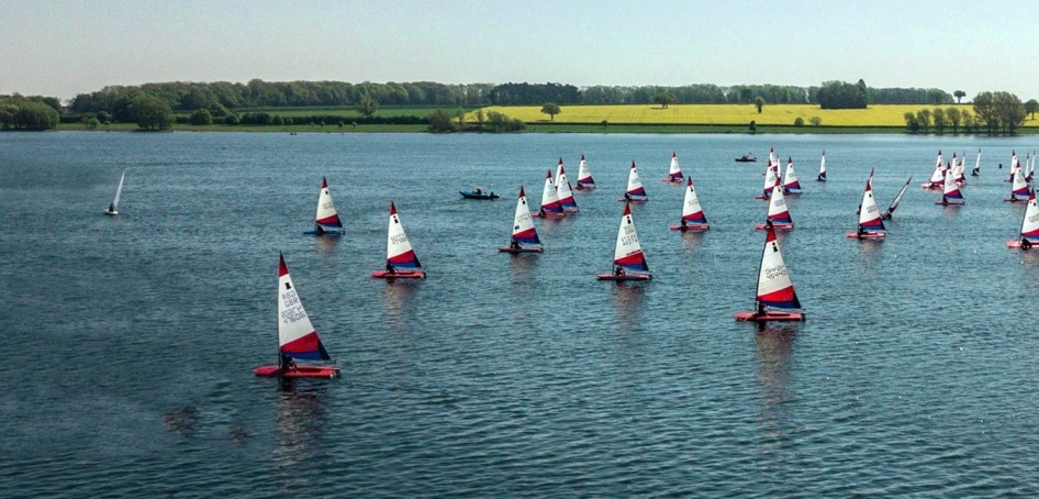 image of an expanse of water with many small white sailing boats on it. 