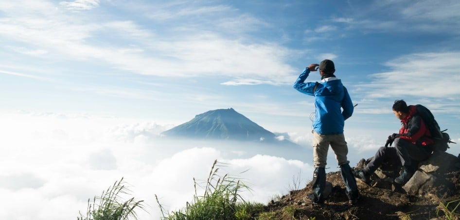 Mountain climbers look across the clouds to another peak