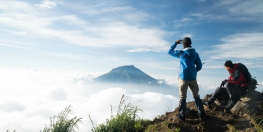 Mountain climbers look across the clouds to another peak